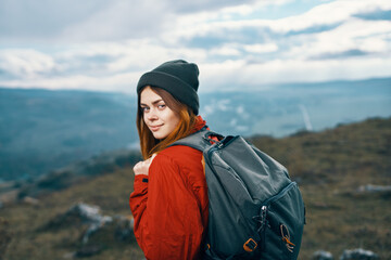 woman jacket hats looking at the mountain in the distance blue sky clouds Model backpack
