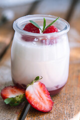 yoghurt with strawberries on wooden background