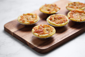 Mini pie from meat and mushrooms in metal tray on marble background