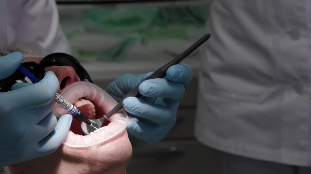 Bracket systems installation process. Patient in the dental chair. Modern orthodontics.