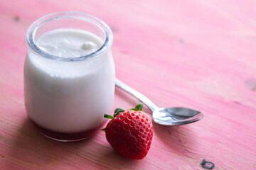 yogurt with strawberries on pink background