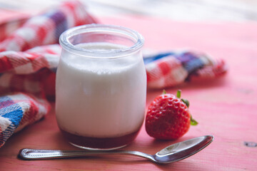 yogurt with strawberries on pink background