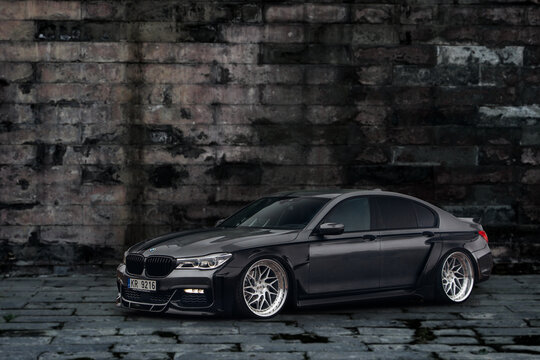 BMW 7 Series G11 with carbon widebody kit in front of stone wall