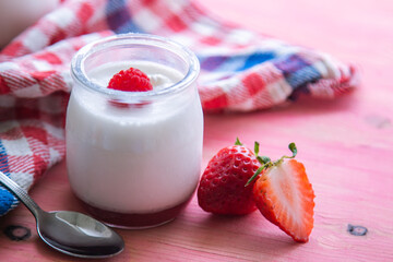 yogurt with strawberries on pink background