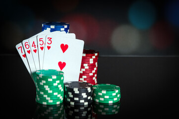 Poker cards with straight flush combination. Close-up of playing cards and chips in poker club. Free advertising space