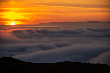  Dreamy misty landscape above the sea of clouds, mountains at sunset in Iceland