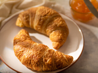Morning breakfast. Croissants with coffee and jam. On a light table
