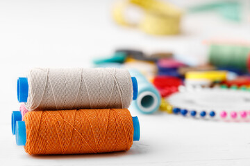 Colorful sewing accessories on white wooden table