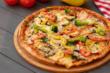 Close up of freshly baked pizza on black wooden table