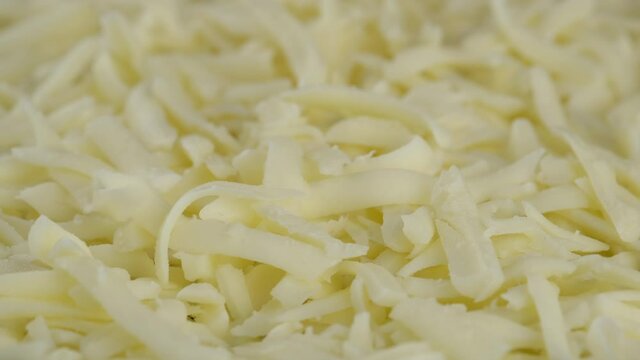 put grated mozzarella cheese close up, Sliding shot. pizza grated mozzarella cheese. 4K UHD video
