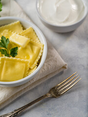 Homemade ravioli or dumplings with sauce on a light background. Recipes