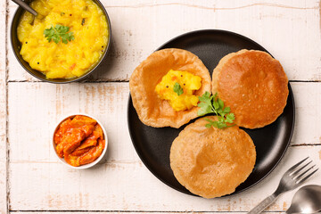 Puri Bhaji North Indian Poori with aalu bhaji , aalu sabji potato spicy recipe breakfast food a deep fried bread of whole wheat flour. poori masala in restaurant Kerala, India, Sri Lanka.