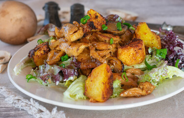 Fototapeta premium fried and chopped chicken breast with potatoes, salad and creamy mushroom sauce