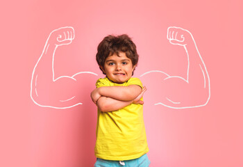 Successful kid in elementary school in front of muscle. Nerd kindergarten kid girl showing biceps....
