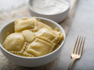 Italian ravioli with sauce on a light table with space for an inscription