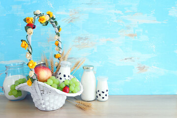 Photo of dairy products over wooden table. Symbols of jewish holiday - Shavuot
