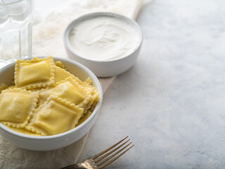 Italian ravioli with sauce on a light table with space for an inscription
