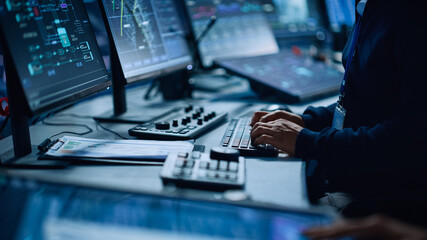 Close Up of a Professional Office Specialist Working on Desktop Computer in Modern Technological Monitoring Control Room with Digital Screens. Manager Typing on keyboard and Using Mouse.