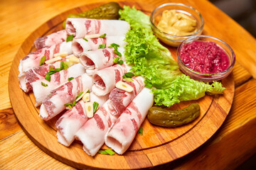 Lard with garlic, mustard and horseradish on a wooden board. Close-up, selective focus