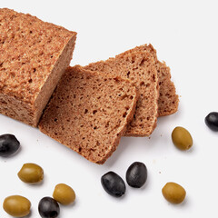 sliced rye bread on a white plate with  olives