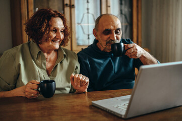 Senior couple using a laptop for a video call with their family