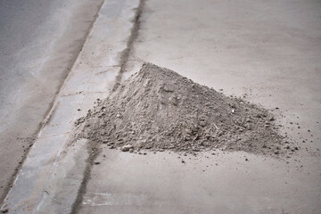 Pile of dust, sand and road debris collected on roadside, cleaning roadside from sand. City cleaning service clean road