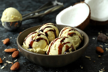 Bowl with ice cream balls and ingredients on black smokey table