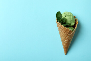 Cone of mint ice cream on blue background