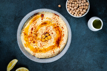 Traditional Middle east appetizer Hummus served with lemon and tahini, seasoned with extra virgin olive oil and paprika in ceramic plate. eastern dish. Vegetarian dish. Traditional dip with chickpea