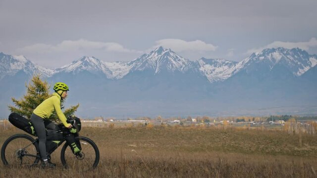 The man and woman travel on mixed terrain cycle touring with bikepacking. The love couple journey with tent in with bicycle bags. Stylish sportswear.