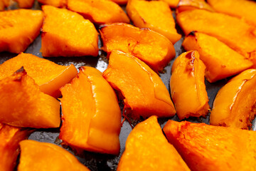 Pieces of pumpkin baked on a baking sheet. Food