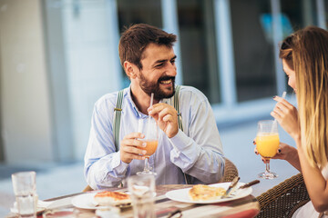Young happy couple eating pizza for lunch in a restaurant