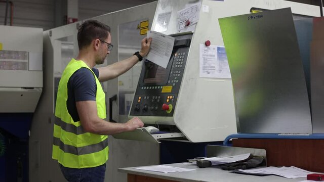 Mitarbeiter kontrolliert Laseranlage in Metallbau-Firma