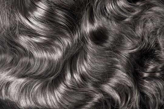 Black Hair Texture. Wavy Long Curly Dark Hair Close Up As Background. Hair Extensions, Materials And Cosmetics, Hair Care. Hairstyle, Haircut Or Dying In Salon.