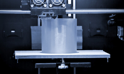 3D printer prints the form of molten plastic blue gray close-up.
