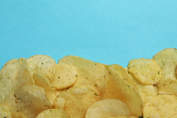 Potato chips on blue background, space for text
