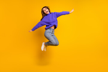 Obraz na płótnie Canvas Full length body size view of attractive cheerful carefree girl jumping having fun fooling isolated over bright yellow color background