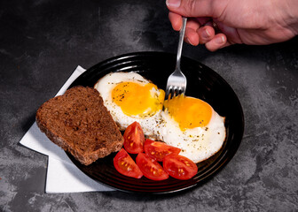 fried eggs and toast, bread, tomato, delicious breakfast, snack, yolk and protein food, background, top view, copy space, eat healthy raw materials. Scrambled eggs. Breakfast. Healthy eating. Close-up