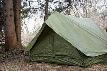 Green tourist tent in the forest