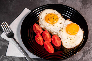 fried eggs and tomato slices, delicious breakfast, snack, yolk and protein food, background, top view, copy space, eat healthy raw materials. Scrambled eggs. Breakfast. Healthy eating. Close-up