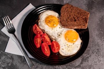 fried eggs and toast, bread, tomato, delicious breakfast, snack, yolk and protein food, background, top view, copy space, eat healthy raw materials. Scrambled eggs. Breakfast. Healthy eating. Close-up