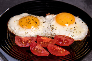 fried eggs and tomato slices, delicious breakfast, snack, yolk and protein food, background, top view, copy space, eat healthy raw materials. Scrambled eggs. Breakfast. Healthy eating. Close-up