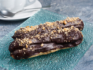 sweet Eclair with chocolate on a glass plate