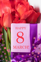 Red tulips and pink gift box with inscription Happy 8 March. Vertical card for the holiday International Women's Day.