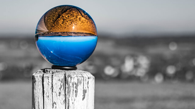 Crystal ball landscape shot with black and white background outside the sphere on a wooden pole near Eichendorf, Bavaria, Germany