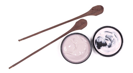 Creamy pink lotion with wooden spoons isolated