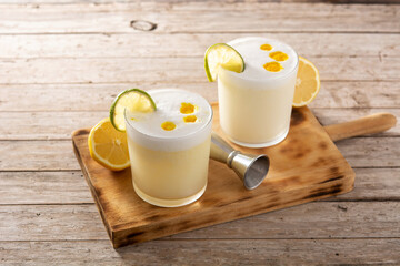 Pisco sour cocktail on wooden table. Traditional peruvian cocktail	