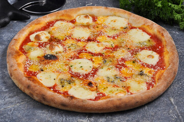 pizza four cheeses on a gray background decorated with greenery