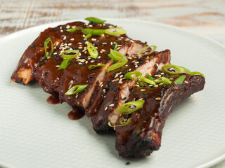pork cherry ribs with barbecue sauce, green onions and sesame seeds