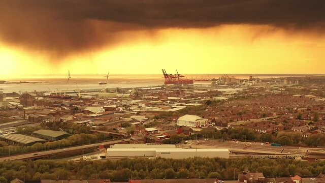 Liverpool Docks And Container Cranes Under Dramatic Rainy Sunset Sky